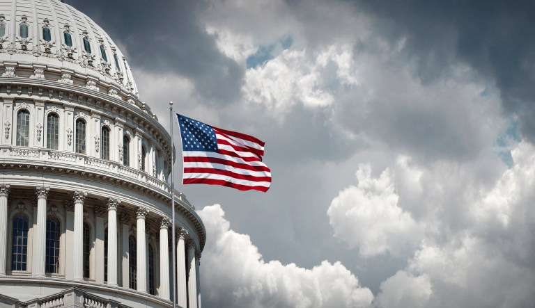 Panoramic view of the United States Capitol and waving American flag in Washington D.C.