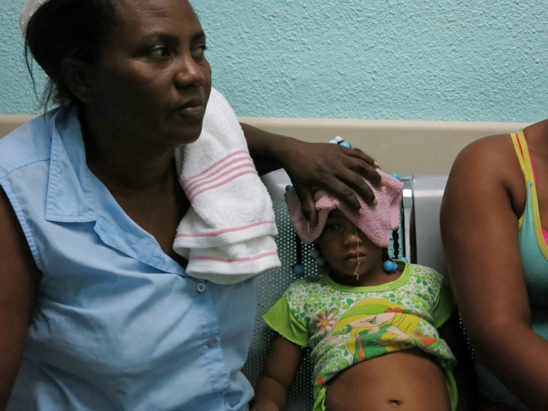 In this May 15, 2014 photo, five-year-old Karla Sepulveda, who suffers chikungunya fever symptoms, waits with her grandmother for treatment in the pediatric area of a public hospital in the coastal town of Boca Chica, Dominican Republic. The mosquito-born virus, common in Africa and Asia, arrived to the Caribbean in late 2013 and has affected more than 10,000 people in the Dominican Republic. (AP Photo/Ezequiel Abiu Lopez)