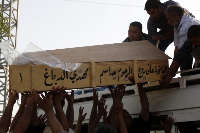   Family members of Bilal Aziz, 20, who was killed in a car bomb attack load his coffin onto a vehicle before burial in Najaf, 100 miles (160 kilometers) south of Baghdad, Iraq, Wednesday, June 13, 2012. A wave of bombings targeted religious processions during the annual pilgrimage commemorating the 8th century death of a revered Shiite imam, killing and wounding scores of people, police said. (AP Photo/Alaa al-Marjani)  