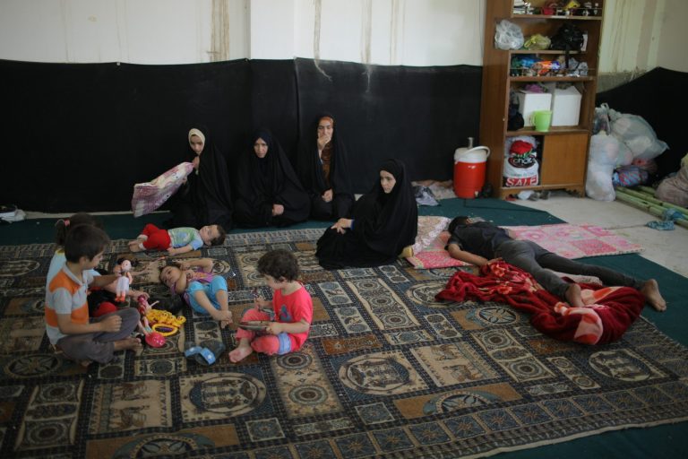 In this Aug. 6, 2014, photo, displaced Iraqis who fled from their towns after advances by Islamic militants take shelter in Najaf, Iraq. Some 50,000 newly displaced Shiite Turkmen arrived the Shiite holy city of Najaf, where they are safe for now _ but not without extreme hardship. They journeyed several hours across Iraq's sprawling deserts. Some traveled without food or water in the blistering heat made worse by an overcrowded buses of hysterical refugees _ many of them far less fortunate, having lost a relative or two at the hands of the unforgiving militants who view them as apostates. (AP Photo/Jaber al-Helo)