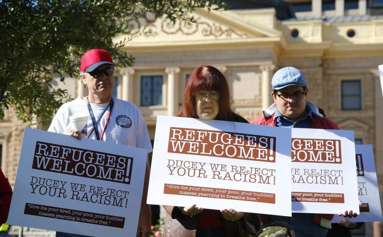 Supporters for the welcoming of Syrian refugees pause during a rally at the Arizona Capitol Tuesday, Nov. 17, 2015, in Phoenix. Arizona Gov. Doug Ducey has joined a growing number of governors calling for an immediate halt to the placement of any new refugees in the wake of terrorist attacks in Paris. The U.S. State Department says Arizona has received 153 Syrian refugees so far this year. (AP Photo/Ross D. Franklin)