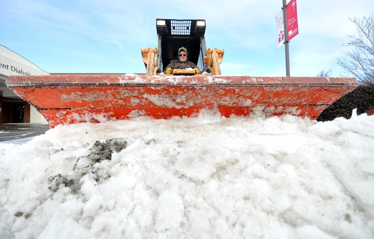 Ronnie Moody of Nabholz Construction Services  plows ice from the parking lot of the St. Bernards Outpatient Dialysis Center on Washington Avenue in Downtown Jonesboro, Ark., Saturday, Dec. 7, 2013. Moody said he and others had been working off and on since about 3 a.m. Saturday clearing key areas around the hospital. (AP Photo/The Jonesboro Sun, Rob Holt)