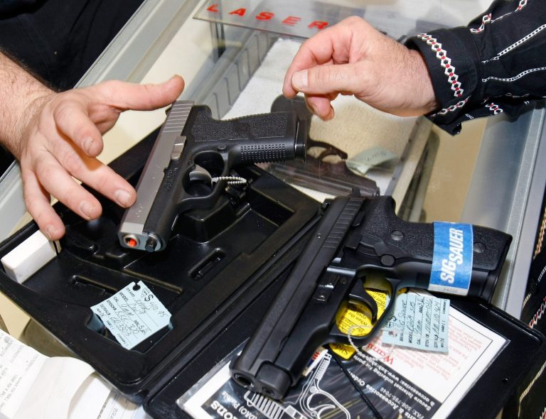 LAS VEGAS - NOVEMBER 14:  The Gun Store sales associate Greg Kohler (L) shows Eric Brandon of Nevada semi-automatic pistols November 14, 2008 in Las Vegas, Nevada. Store manager Cliff Wilson said he's seen a large spike in sales since Barack Obama was elected president on November 4, with customers citing fears about the president-elect's record on firearms. The election, combined with a slumping economy, has contributed to an overall increase of 25-30 percent in gun sales at the store, Wilson said.  (Photo by Ethan Miller/Getty Images)