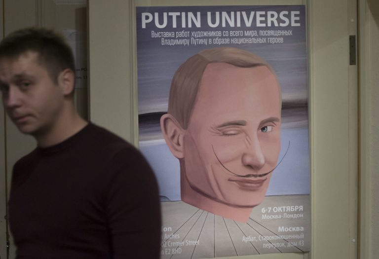 A man passes by a poster with an artwork showing Russian President Vladimir Putin as Spanish artist Salvador Dali during the 