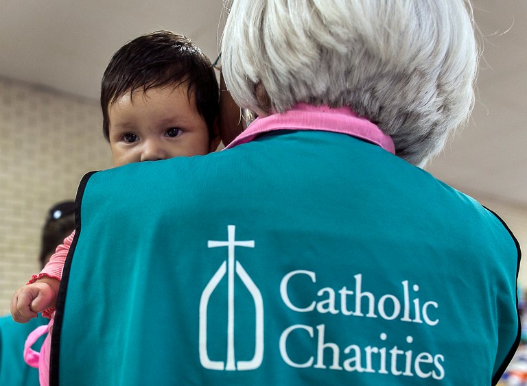 Two-month-old Allison, from El Salvador, is cared for by Sacred Hearts Catholic Charities volunteer Luisa Escamilla, as Allison's mother showers at the shelter set up for immigrant families from Central America in McAllen, Texas, in this photo taken July 1, 2014. (AP Photo/Austin American-Statesman, Rodolfo Gonzalez)