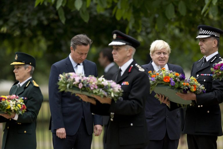 Britain's Prime Minister David Cameron, second from left, and London Mayor Boris Johnson, fourth from left, stand beside senior representatives from the ambulance, left, fire, third left, and police services as they wait to lay wreaths at the 7/7 memorial in Hyde Park in London, Tuesday, July 7, 2015. Britons marked the 10th anniversary of suicide bomb attacks on London's transit system Tuesday, as Prime Minister David Cameron said the recent slaying of 30 British tourists in Tunisia was a reminder that terror threats remain real and deadly. (AP Photo/Matt Dunham)