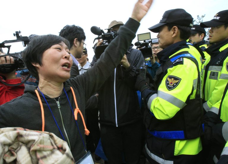 A weeping relative of a missing passenger aboard the sunken ferry Sewol shouts as she tries to march toward the presidential house to protest the government's rescue operation in Jindo, South Korea, Sunday, April 20, 2014. After more than three days of frustration and failure, divers on Sunday finally found a way into the submerged ferry off South Korea's southern shore, discovering more than a dozen bodies inside the ship and pushing the confirmed death toll to over four dozen, officials said. (AP Photo/Ahn Young-joon)