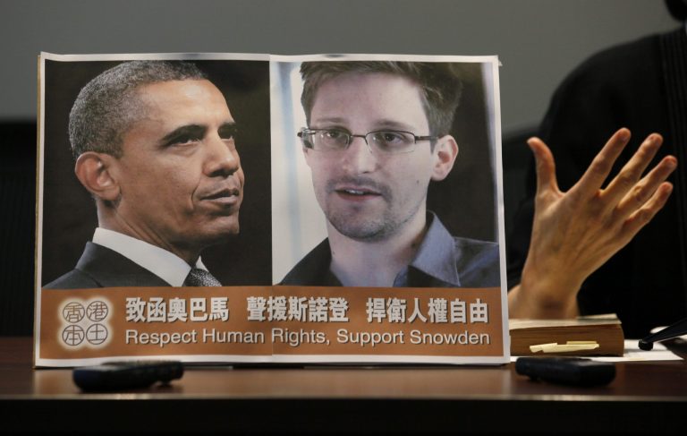 Pro-democractic legislator Claudia Mo Man-ching speaks next to a picture of U.S. President Barack Obama and Edward Snowden during a news conference in Hong Kong Friday, June 14, 2013.  Two lawmakers in Hong Kong said on Friday that they had written to U.S. President Obama to try to persuade him not to bring charges against the former US intelligence contractor Snowden.  Snowden revealed last weekend he was the source of a major leak of top-secret information on NSA surveillance, saying he was uncovering wrongdoing.   He spoke to reporters from an undisclosed location in the semiautonomous Chinese territory of Hong Kong.(AP Photo/Kin Cheung)