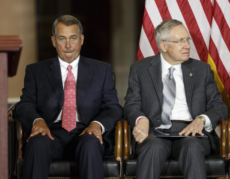 In this Sept. 10, 2014, photo, House Speaker John Boehner of Ohio, left, sits with Senate Majority Leader Harry Reid of Nev., on Capitol Hill in Washington, as Congress honored victims of the terror attacks of September 11, 2001, during a 