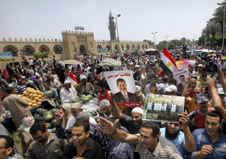 Supporters of ousted Egyptian President Mohammed Morsi hold his posters during a march in front of Amr Ibn Al As mosque in Cairo, Egypt, in July 2013. (AP Photo/Amr Nabil)