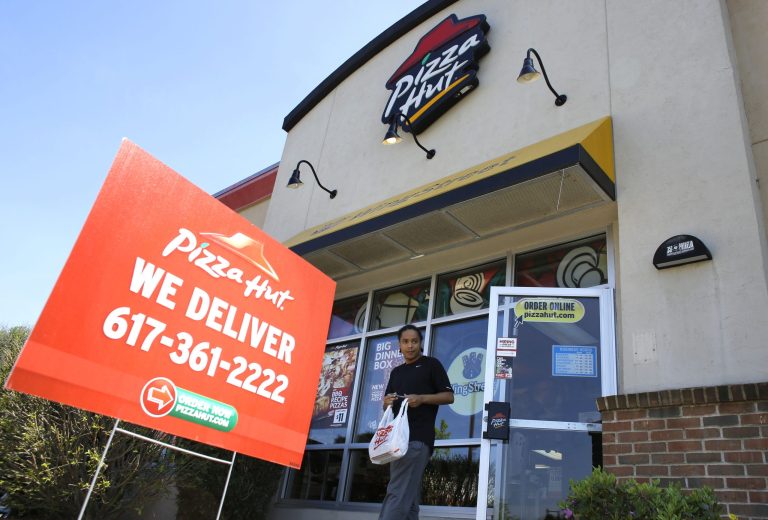 In this Wednesday, May 14, 2014 photo, a customer departs a Pizza Hut restaurant location, in Boston. Yum Brands, parent company of Pizza Hut, Taco Bell, and KFC, reports quarterly financial results on Wednesday, July 16, 2014. (AP Photo/Steven Senne)