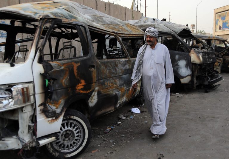 A man looks at the site of a car bomb attack in the Shula neighborhood of Baghdad, Iraq, Sunday, Oct. 12, 2014. A series of car bomb attacks in Iraq's capital killed and wounded dozens of people in Shiite areas Saturday, authorities said. (AP Photo/Karim Kadim)
