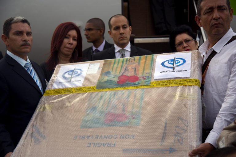 Venezuelan government handlers hold a package containing the painting 