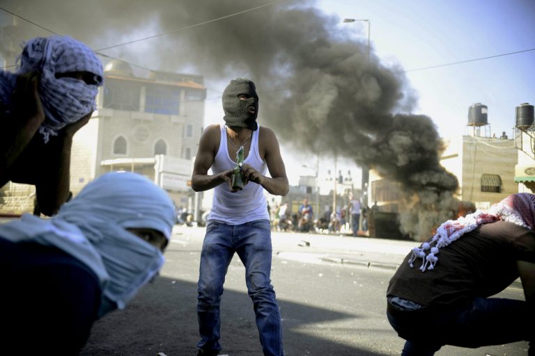 A Palestinian holds a Molotov cocktail during clashes with Israeli border police in Jerusalem on Wednesday, July 2, 2014. (AP Photo/Mahmoud Illean)