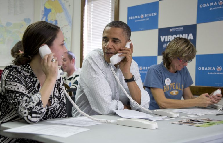 In this Oct. 14, 2012, file photo, President Barack Obama makes phone calls to volunteers at a Obama campaign office with Alexa Kissinger, left, and, Suzanne Stern, right, in Williamsburg, Va. The vaunted data-driven machine that twice got Obama elected is dusting itself off to help elect Hillary Clinton. (AP Photo/Carolyn Kaster)