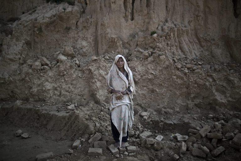 In this Sunday, March 2, 2014, photo, Amna Bhatti, 60, a Pakistani brick factory worker, poses for a picture at the site of her work in Mandra, near Rawalpindi, Pakistan. Amna is in debt to her employer the amount of 150,000 rupees (approximately $1,500). (AP Photo/Muhammed Muheisen)