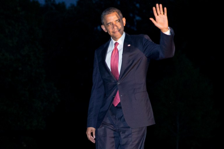 President Barack Obama waves to the media as he returns at dusk on the South Lawn of the White House in Washington, Friday, June 6, 2014, after attending remembrance activities on the 70th anniversary of D-Day in Normandy, France. (AP Photo/Jacquelyn Martin)