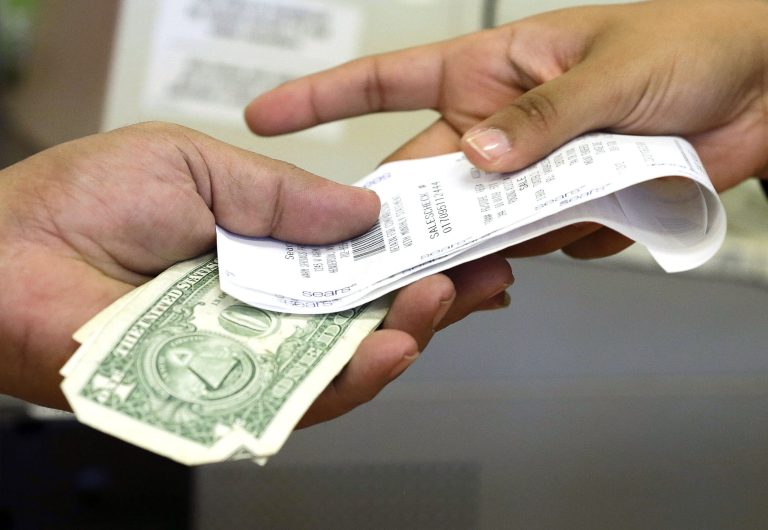 FILE - In this Friday, Nov. 23, 2012 file photo, a cashier hands a customer his change and receipt during a transaction at a Sears store, in Henderson, Nev. The University of Michigan issues its index of consumer sentiment for June, 2014 on Friday, June 27, 2014. (AP Photo/Julie Jacobson, File)