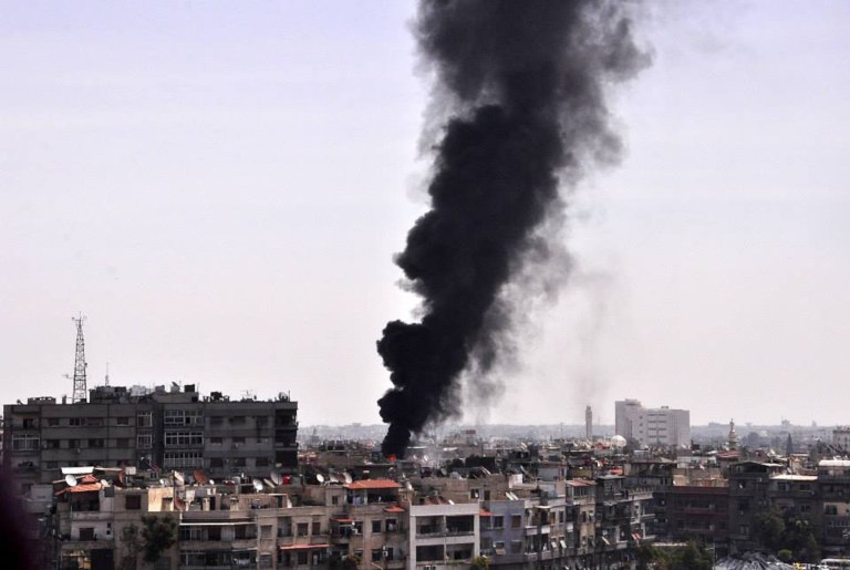 In this photo released by the Syrian official news agency SANA, black smoke rises from the rooftop of a building that was, according to SANA, attacked by a mortar shelled by the Syrian rebels in Damascus, Syria, Saturday, April 5, 2014. Al-Qaida's leader, Ayman al-Zawahri, called on fighters to determine who killed his chief representative in Syria, a man many militant groups believe died at the hands of a rival militia, in a move that highlighted a conflict between rebels that has killed hundreds. (AP Photo/SANA)