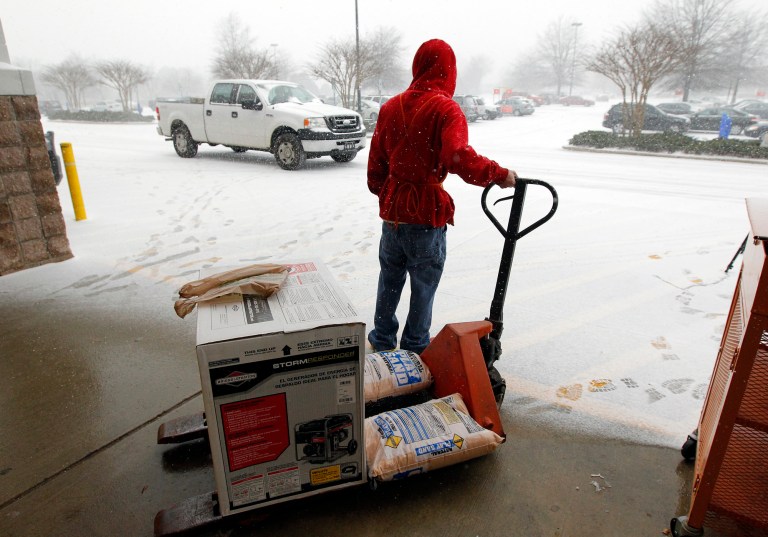 In this Wednesday, Feb. 12, 2014, photo store worker Chris Craft pulls a generator and some sand out to the front for a customer at the Home Depot in Cary, N.C.  Home Depot Inc. estimated that it lost $100 million in the month of January, because of weather. (AP Photo/The News & Observer, Chris Seward)