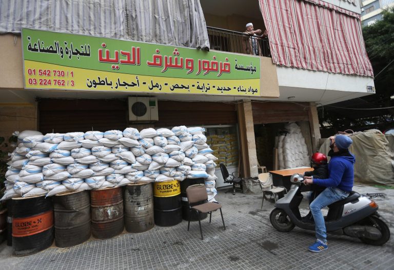 FILE- In this Tuesday, Jan. 28, 2014 file photo, a Lebanese man sits on his scooter as he speaks with his father on the balcony, in a Shiite neighborhood of a southern suburb of Beirut, Lebanon. After a wave of car bomb attacks on Hezbollah's stronghold south of Beirut that left scores of people dead or wounded over the past three months, shop owners scared of more bombs have set up sand barriers in front of their institutions to reduce damage in case more blasts occur. The attacks that hit the south Beirut area known as Dahiyeh (suburb) has sacred many people in the area and increased security measures by Lebanese troops and members of the militant group.(AP Photo/Hussein Malla, File)