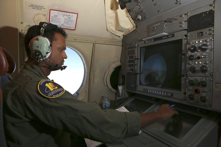 In this Wednesday, March 26, 2014 photo, Tactical Coordinator Imray Cooray operates from his station on board a Royal Australian Air Force AP-3C Orion during a search for the missing Malaysia Airlines Flight 370 in the southern Indian Ocean. A French satellite scanning the Indian Ocean for remnants of the missing jetliner found a possible plane debris field containing 122 objects, a top Malaysian official said Wednesday, calling it 