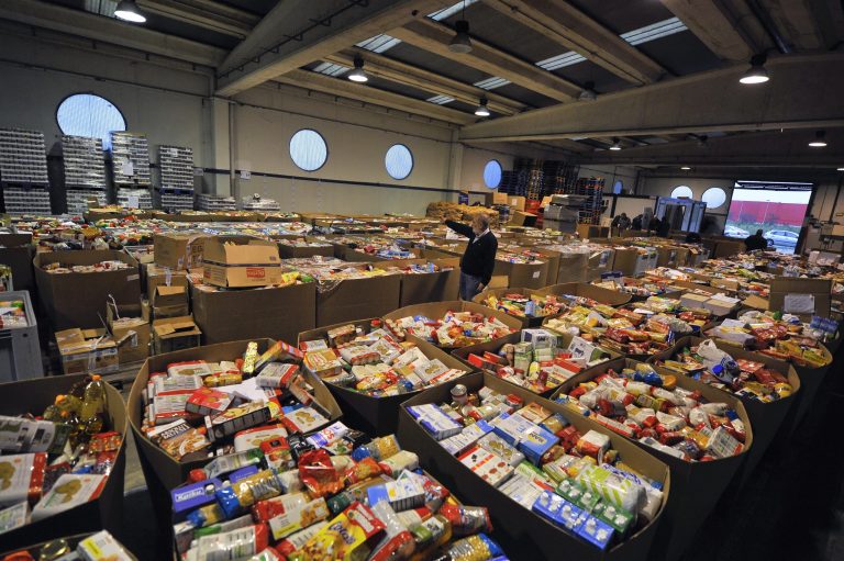   A man inspects inside a food bank full of cardboard boxes with more than 70 tons of foods to distribute to people left needy by Spain's critical economic crisis, in Pamplona, northern Spain, Tuesday Dec. 4, 2012. The number of people officially registered as unemployed in Spain has edged up toward 5 million as the country's recession shows few signs of abating and its struggling banks await crucial bailout cash, Spain's Labor Ministry said Tuesday. (AP Photo/Alvaro Barrientos)  