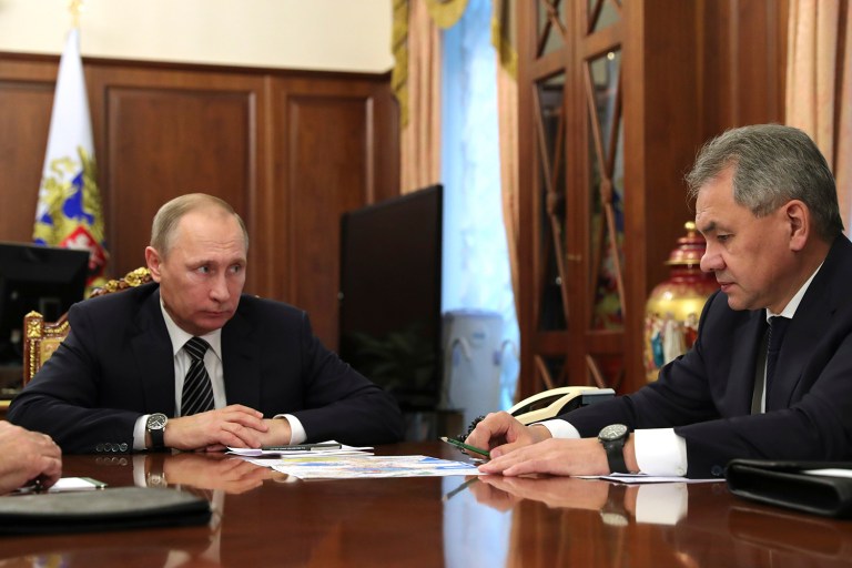 Russian President Vladimir Putin, left, listens to Defence Minister Sergei Shoigu in Moscow. Putin is ordering to scale down the Russian military presence in Syria. Putin made the statement Thursday while declaring that a cease-fire in Syria brokered by Russia and Turkey will start at midnight. (Mikhail Klimentyev/Sputnik, Kremlin Pool Photo via AP)