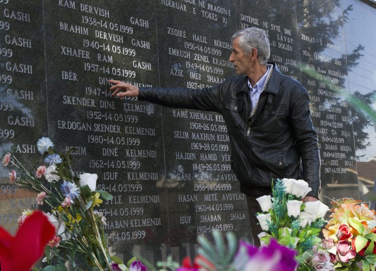 Rexhe Kelmendi, one of three survivors of the Cuska massacre, points out the names of family members as he visits the Martyr's cemetery in the village of Cuska, Kosovo on Tuesday, Feb. 11, 2014. Serbia's war crimes court on Tuesday convicted nine former paramilitaries of the brutal killings of more than 100 ethnic Albanian civilians during the Kosovo war and sentenced them to between two and 20 years in prison. The crime by the 