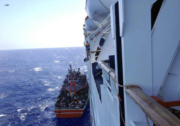 This Thursday, Sept. 25, 2014 photo taken from a cruise ship that rescued the migrants from a small boat stranded off the east Mediterranean island's main Limassol port, Cyprus, shows apparent refugees on the boat. More than 300 people, apparent refugees fleeing from Syria, refused to leave the cruise ship, a cruise line official said Thursday.(AP Photo/Haris Milonas)