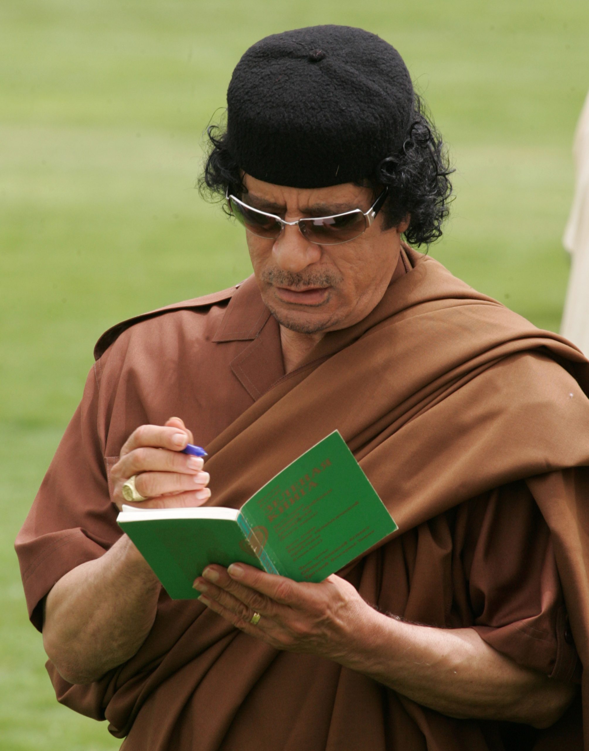 Muammar Qaddafi autographs his book (‘The Green Book’) for Vladimir Putin in 2008