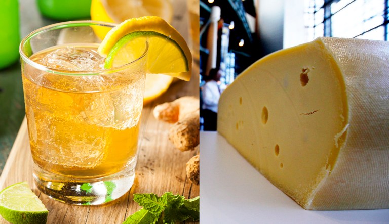 A glass of ginger ale is pictured on the left; a freshly cut wheel of Swiss cheese is pictured on the right.