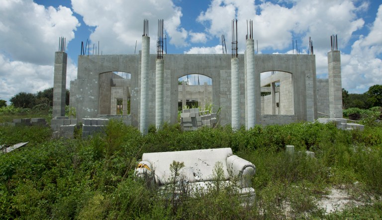 In this Aug. 19, 2010 photo, a dumped sofa sits in front a half started house in Davie, Fla. Only three houses were started in the multi-million dollar, Parking Estate housing development in Davie, Fla. The recession that began in December 2007, after the housing bubble burst, became the Great Recession once the financial crisis erupted in September 2008. Economic recoveries that follow a financial crisis are typically long-lasting. Banks usually take years to resume lending normally.