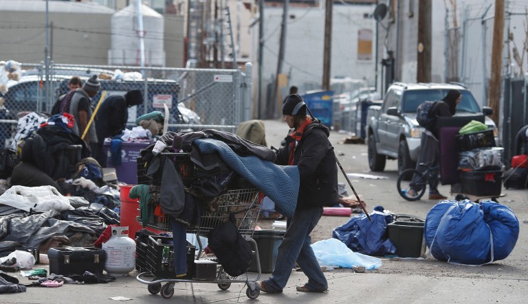 Homeless people clear their belongings of from a camp near the Denver Rescue Mission, Tuesday, March 8, 2016, in Denver. The city has spent months urging the campers to move into shelters and get rid of makeshift structures that officials say pose a health hazard.