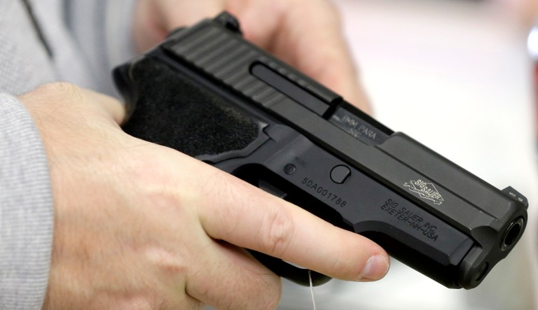 David Foley holds a handgun while shopping at the Spring Guns and Ammo store Monday, Jan. 4, 2016, in Spring, Texas. 