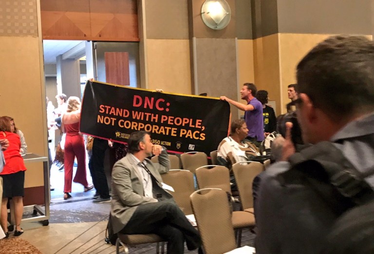 Climate activists disrupt DNC meeting over party’s backtrack on ban of fossil fuel donations