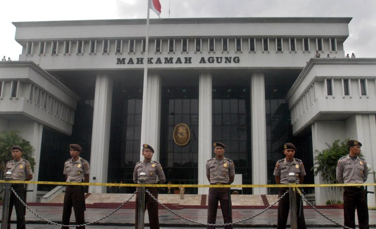 Indonesian police stand guard at the Akbar Tandjung verdict reading, Thursday, Feb. 12, 2004, outside Supreme Court in Jakarta, Indonesia. In a case with wide implications for Indonesia's presidential race, the Supreme Court on Thursday was set to rule on an appeal by Tandjung, the country's parliamentary speaker, who hopes to run for president despite a corruption conviction. 