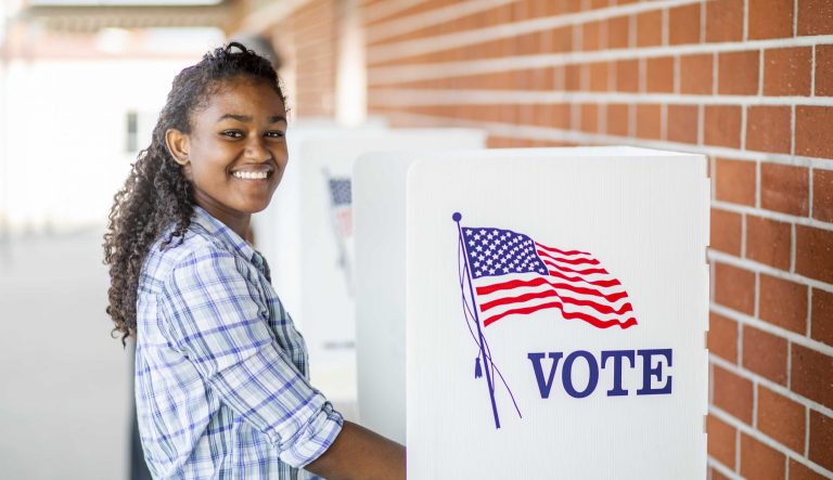 A young, black girl voting on election day.