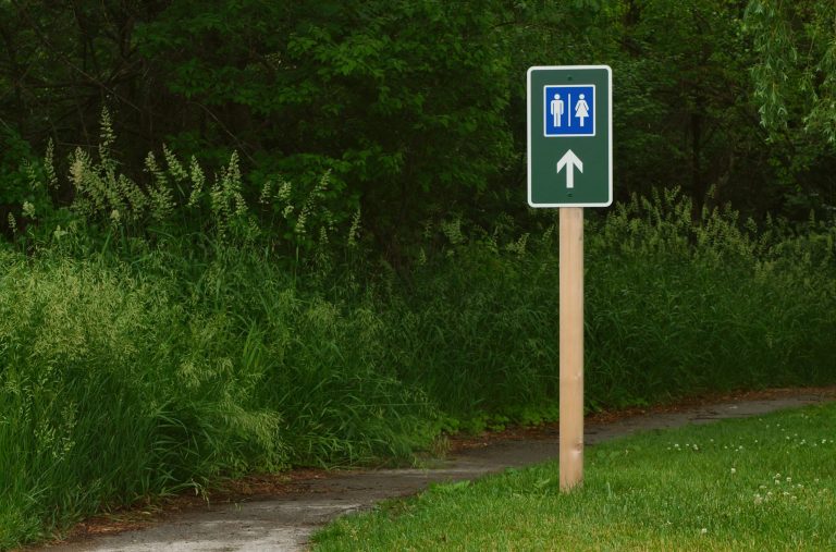 Sign for a restroom somewhere in the woods.