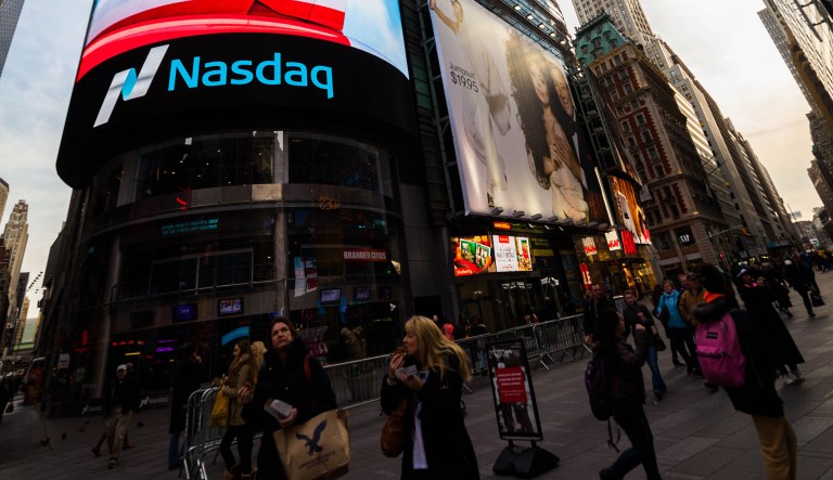 View of Times Square, New York City, New York on December 4, 2014. Pedestrians and tourists on street. Nasdaq billboard in view in front of Conde Nast building.