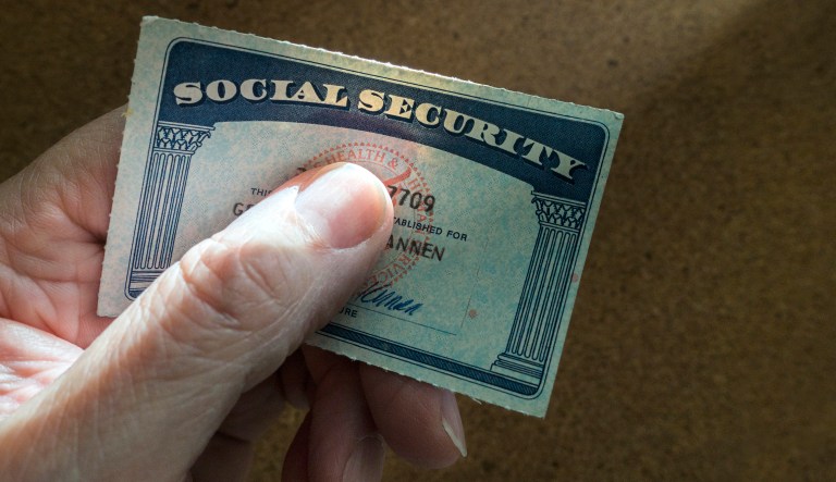 A man holds a social security card.