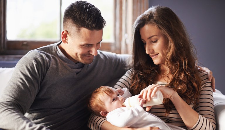 A family is shown while the mother feeds the baby.