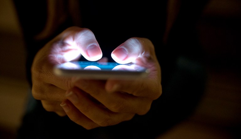 A person uses their smartphone during nighttime.