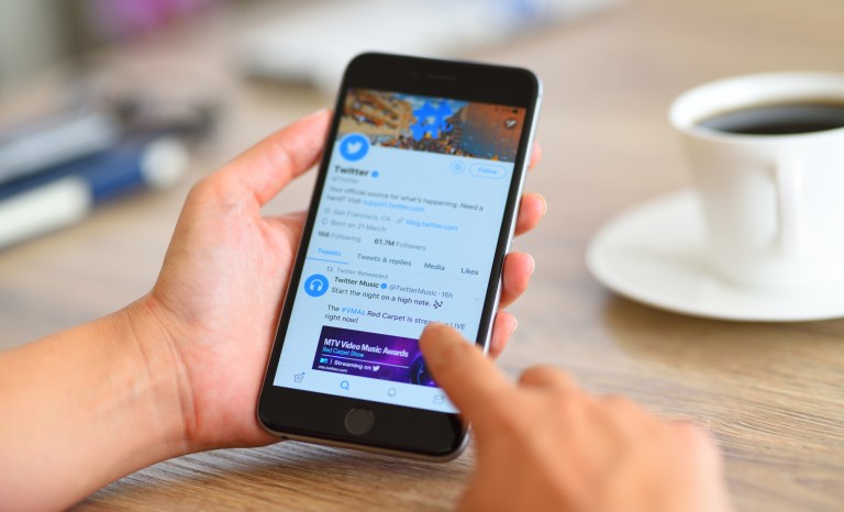 A woman using smart phone to go on Twitter.