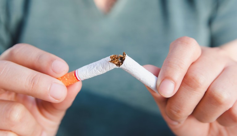 Stop smoking: woman breaking the cigarette.