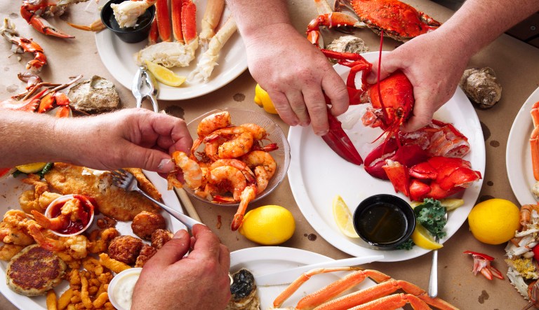 A meal of crab, lobster, and other seafood is shown.