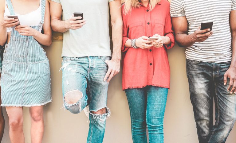 A group of millennials on their cell phones.