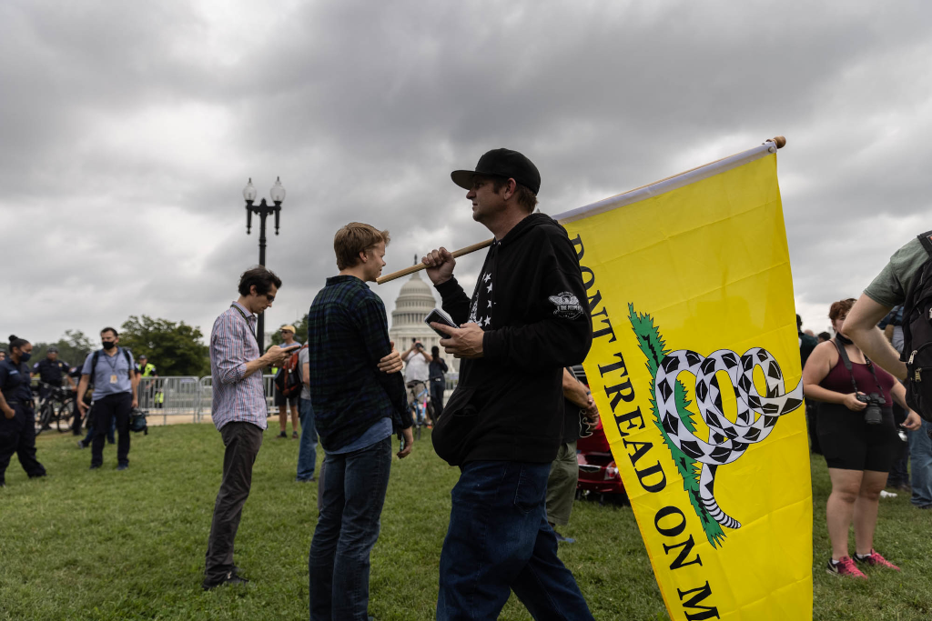A protester at the "Justice for J6" event holds a flag that reads, "Don't tread on me."
