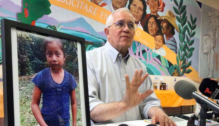 Annunciation House director Ruben Garcia answers questions from the media after reading a statement from the family of Jakelin Caal Maquin, pictured at left, during a press briefing at Casa Vides, Saturday, Dec. 15, 2018, in downtown El Paso, Texas. Maquin had received her first pair of shoes several weeks ago, when her father said they would set out together for the U.S., thousands of miles from her impoverished Guatemalan village. Instead she died in a Texas hospital two days after being taken into custody by U.S. Border Patrol agents in a remote stretch of New Mexico desert.