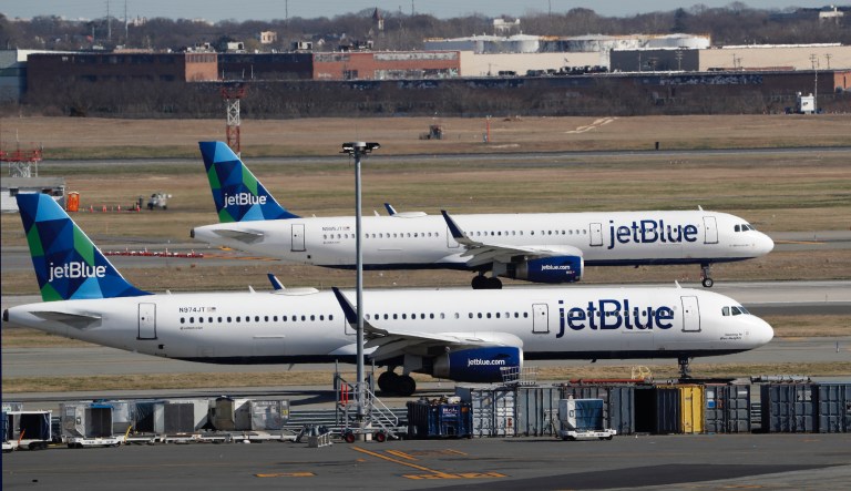 Two jetBlue airplanes line up in preparation for take-off, Saturday, March 14, 2020, at John F. Kennedy International Airport in New York. Travel restrictions and a slump in demand due to the coronavirus have forced airlines to cancel many flights and temporarily reduce staff.